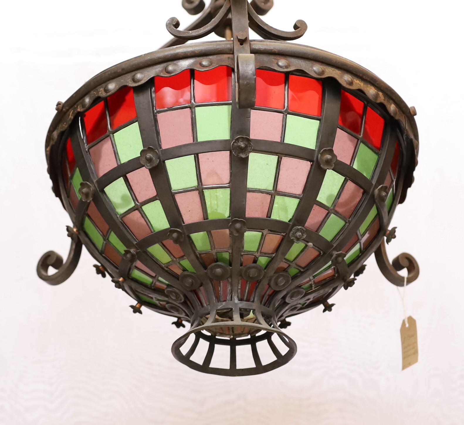 An English Arts & Crafts wrought iron and stained glass basket shaped light fitting, height 70cm to the top of the fitting with additional 10 link heavy wrought iron chain. width 52cm.